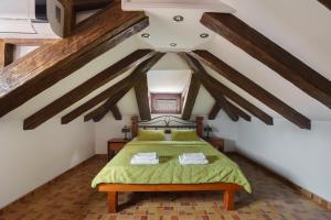 a bedroom with a green bed in a attic at Apartments Wine House Old Town in Kotor