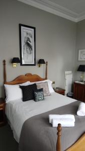 a bedroom with a large bed with black and white pillows at 17 Wilmington Square in Eastbourne