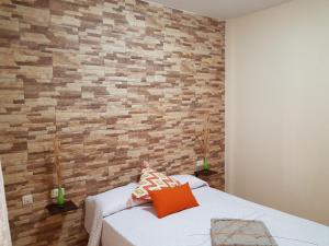 a bedroom with a brick wall and a bed at Aptos. Las Salinas in Garachico