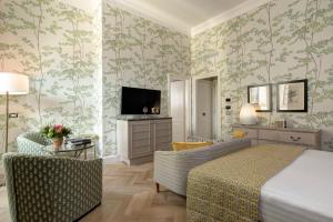a bedroom with a bed and a living room at Rocco Forte Hotel Savoy in Florence