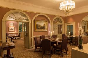a dining room with tables and chairs and a chandelier at The Devonshire Arms Hotel & Spa - Skipton in Bolton Abbey