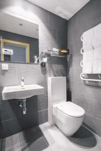 a bathroom with a white toilet and a sink at Dunetton - self check-in hotel in Klaipėda