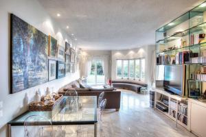 a large living room with a couch and a tv at Capo Al Mare villa Sani in Sani Beach