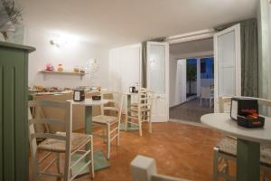 una cucina e un soggiorno con tavolo e sedie di CORTE DELL'IMMACOLATA AL MARE a Marina di Mancaversa