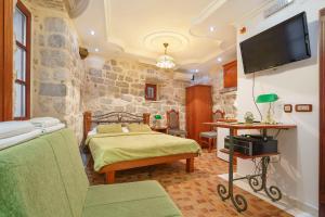 a bedroom with two beds and a flat screen tv at Apartments Wine House Old Town in Kotor