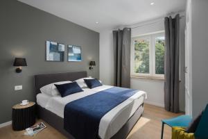 ein Schlafzimmer mit einem großen Bett und einem Fenster in der Unterkunft Apartments Zulijani House Helis B1 & B6 in Rabac
