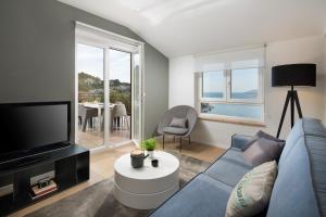 a living room with a blue couch and a tv at Apartments Zulijani House Helis B1 & B6 in Rabac