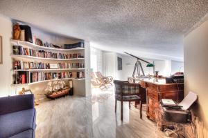 a living room with a desk and a library with books at Capo Al Mare villa Sani in Sani Beach