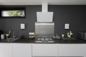 a kitchen with a sink and a stove top oven at Chill-out in Nieuwe Wetering