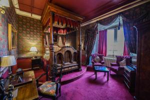 1 dormitorio con cama con dosel y alfombra morada en Lumley Castle Hotel, en Chester-le-Street