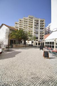 a street with a large building in the background at Apartment Praia Rocha Waterside Blue in Portimão