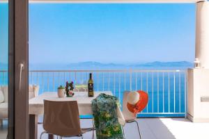 a dining room with a table and a view of the ocean at Villas d'Orlando - with private pool and sea view in Capo dʼOrlando
