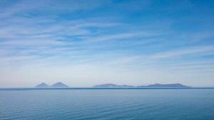 a large body of water with mountains in the distance at Villas d'Orlando - with private pool and sea view in Capo dʼOrlando