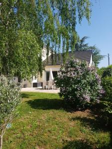 una casa blanca con un patio con un árbol en La Soierie, en Châteauroux