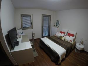 a bedroom with a bed and a desk with a television at Vv Vistamar in Santa Cruz de Tenerife
