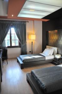 a bedroom with two beds and a desk and window at MonarC Hotel in Tirana