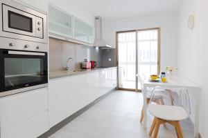 a white kitchen with a table and a microwave at Hola Málaga Premium Centro in Málaga