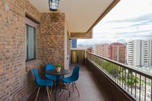 - Balcón con mesa y sillas en un edificio de ladrillo en Hola Málaga Premium Centro, en Málaga