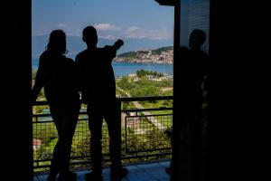 a group of people standing on a balcony looking out at the water at Villa Megdani B in Ohrid