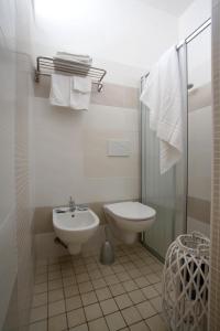 a bathroom with a toilet and a sink and a shower at Hotel Tosi in Riccione