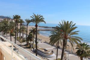 a view of a beach with palm trees and the ocean at La Santa María in Sitges