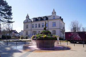 a large building with a fountain in front of it at Country Hotel Timmendorfer Strand in Timmendorfer Strand