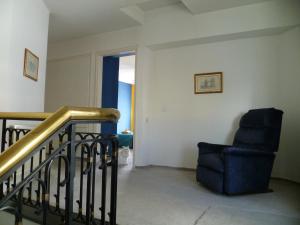un salon avec un escalier et une chaise dans l'établissement Double room with ensuite bathroom at Datacom building, à Nicosie