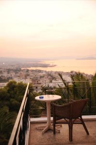 uma mesa e 2 cadeiras numa varanda com vista em Akrotiri Hotel em Chania Town