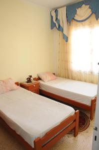 2 camas en una habitación con ventana en City Apartment Rades Tunis free Wifi en Radès