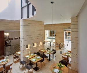 a dining room with tables and chairs in a restaurant at Hotel Rey Alfonso X in Seville