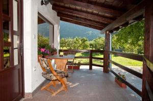 a porch with a table and a chair on a balcony at Pensiunea din Livada in Bran