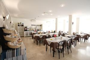 a restaurant with tables and chairs in a room at Hotel Tosi in Riccione