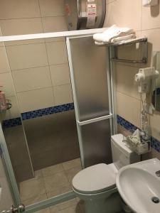 un bagno con doccia, WC e lavandino di Home Inn a Jincheng