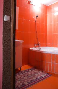 an orange tiled bathroom with a tub and a sink at Pensiunea Nicol in Valea Iasului +25 photos