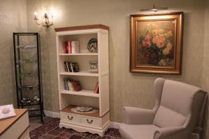 sala de estar con estante de libros y silla en Aitna B&B, en Catania