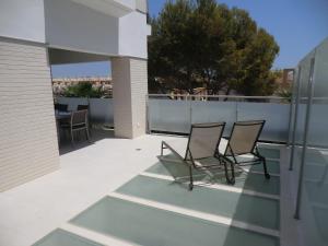 dwa krzesła siedzące na balkonie budynku w obiekcie Casas Holiday - El Mirador de Villamartin w mieście Los Dolses