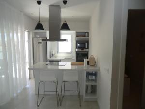 una cocina con una isla blanca en una habitación en Casas Holiday - El Mirador de Villamartin, en Los Dolses