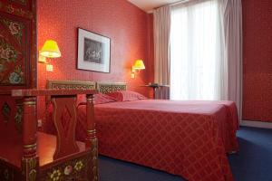a red bedroom with a bed and a window at Hotel Agora in Paris