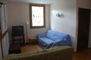 a living room with a blue couch and a window at 1 Carrer de la Carrerada in Esterri d'Àneu