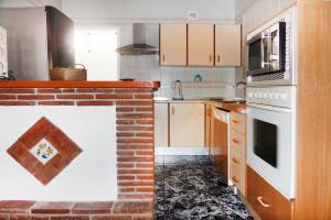 cocina con chimenea de ladrillo en el centro en Cortijo Luque, en Nerja