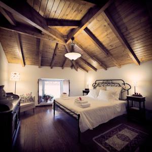 a bedroom with a large bed with a wooden ceiling at Quinta da Fontoura in Alquerubim