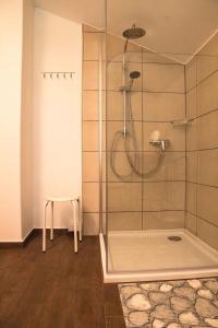 ein Bad mit einer Dusche und einem Hocker in der Unterkunft Villa Silvanus in Ebensee