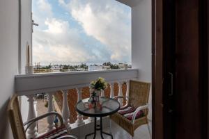 a balcony with a table and chairs and a window at Olympus Studios in Malia