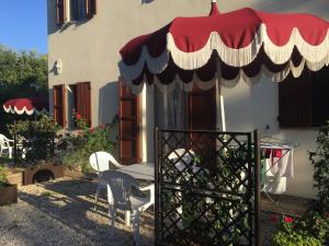 patio ze stołem i czerwono-białym parasolem w obiekcie Country House Sant'Angelo w mieście Senigallia