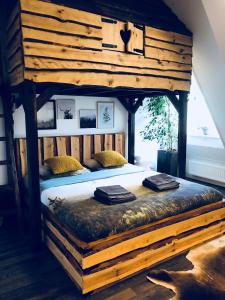 sypialnia z drewnianym łóżkiem w pokoju w obiekcie Happy Bentveld Guesthouse w mieście Bentveld