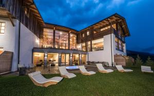 a group of chairs on a lawn in front of a house at Miraval NaturHotel in Badia