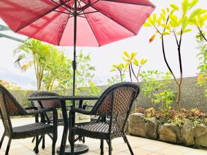 台東市的住宿－台東上弦月民宿，庭院内桌椅和遮阳伞