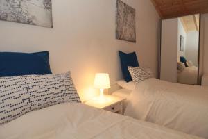 a bedroom with two beds and a lamp and a mirror at Casa Sto. António in Zambujeira do Mar