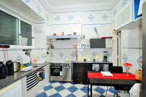 a small kitchen with a red table in it at Suites & Apartments DP VFXira in Vila Franca de Xira