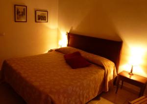 een slaapkamer met een bed met twee lampen erop bij Casale Praia in Letojanni +6 foto's